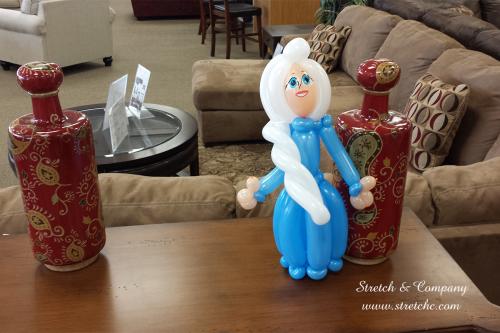 Balloon twisting princess in blue dress with white hair