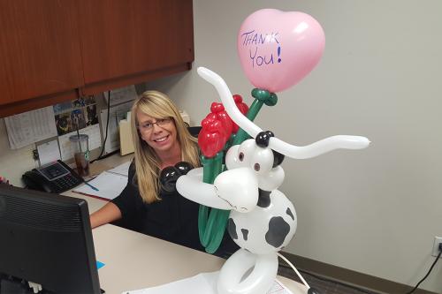 Balloon animal cow holding roses and heart balloon delivery
