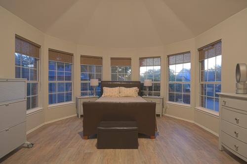 Real Estate Photo - Primary bedroom with a curved wall of bay windows at sunset.