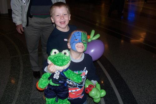 Young Dallas Mavericks fan with face painting, balloon, and stuffed frog